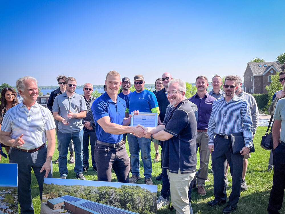 Vice President of Development accepts a certificate of recognition from the City of Wayzata for the solar projects Blue Horizon Energy built.
