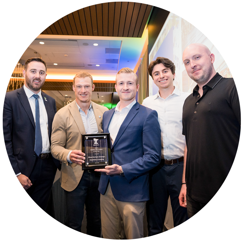 Leaders from Bridge Commercial Real Estate and Blue Horizon Energy pose together after being awarded Solar Project of the Year by MnSEIA.